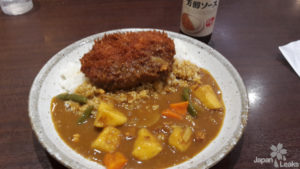 Foto einer Portion Gemüse-Curry mit frittierter Frikadelle als Topping.