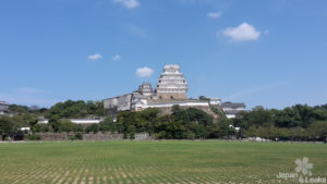 Sicht auf die Burg Himeji über ein Feld.