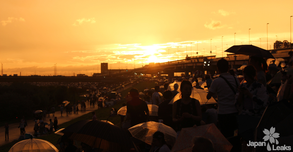 Foto eines Sonnenuntergangs mit vielen Regenschirmen.